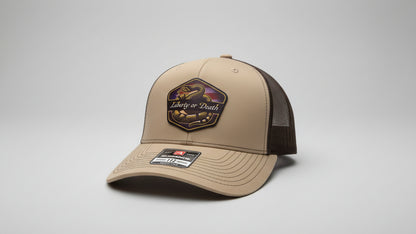Khaki and chocolate‑brown trucker hat featuring a leather ‘Liberty or Death’ patch on a gray background, Hollarwood Outfitters