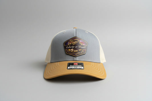 liberty or death UV printed patch on a heather/birch/amber gold trucker hat, Hollarwood Outfitters