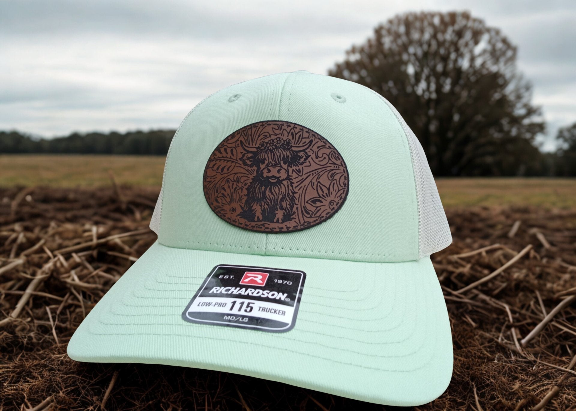 Light green trucker hat featuring a leather Highland Cow patch with Richardson logo on a field background, Hollarwood Outfitters