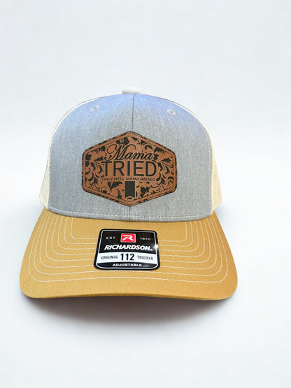 Heather/Birch/Amber Gold trucker hat featuring a leather ‘Mama Tried’ patch on a white background, Hollarwood Outfitters